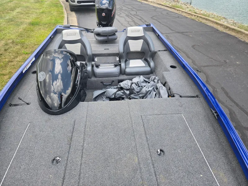 Slide: The Image of 2021 Lowe Stinger 188 boat with dual seats and outboard motor, parked near water. - 18