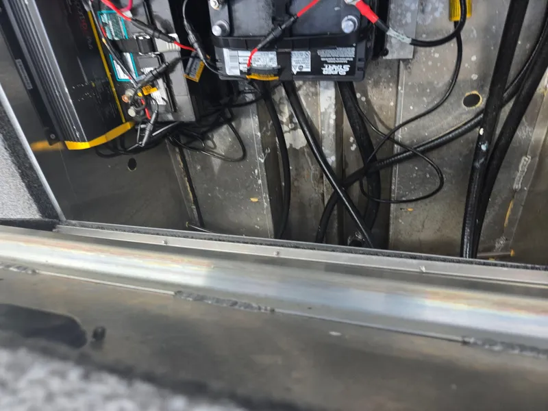 Slide: The Image of 2021 Lowe Stinger 188 boat battery compartment with wiring and connections. - 23