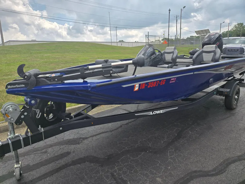 Slide: The Image of 2021 Lowe Stinger 188 boat on trailer, blue exterior, parked on asphalt. - 6
