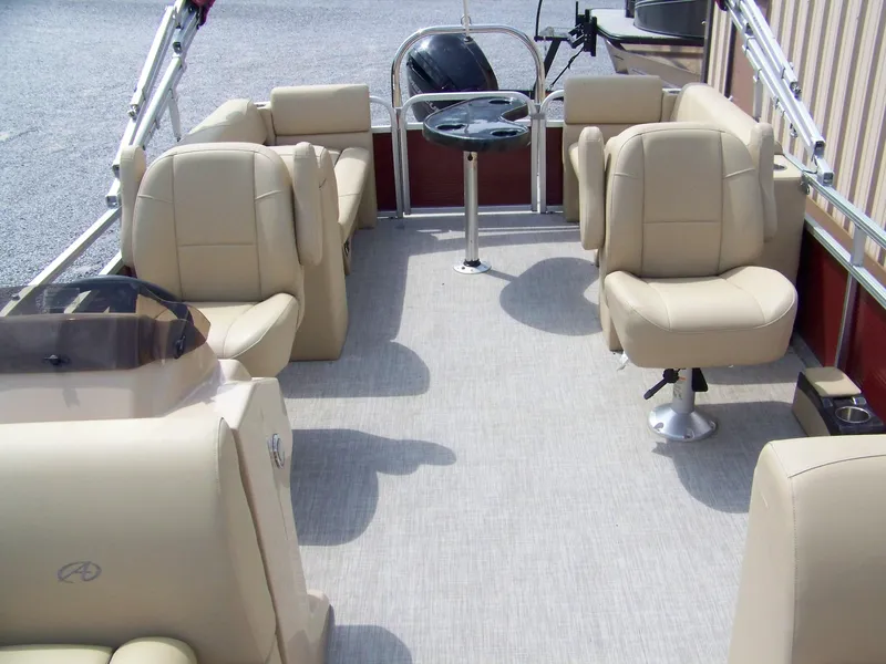 Slide: The Image of 2020 Avalon GS Quad Lounger boat interior with beige seating and steering console. - 4