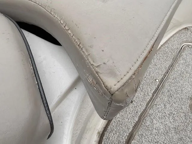 Slide: The Image of Worn upholstery on 2004 Sea Ray 240 Sundeck boat seat, showing visible wear and tear. - 13