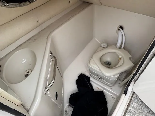 Slide: The Image of 2004 Sea Ray 240 Sundeck boat interior with sink and portable toilet. - 14