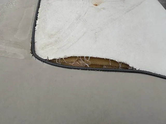 Slide: The Image of Damaged upholstery on 2004 Sea Ray 240 Sundeck boat, showing exposed interior material. - 19