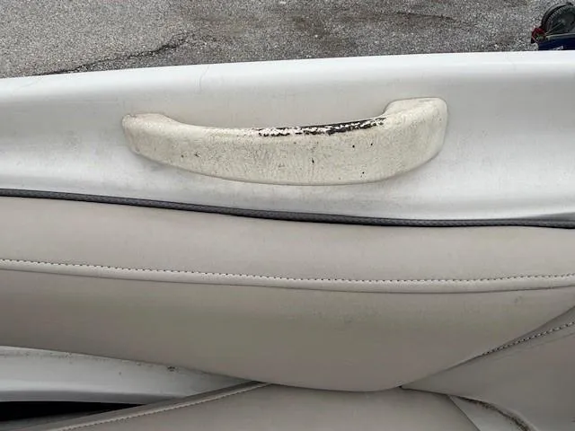 Slide: The Image of 2004 Sea Ray 240 Sundeck interior with worn handle and beige upholstery. - 20