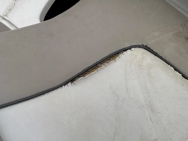 Slide: The Image of 2004 Sea Ray 240 Sundeck upholstery with visible wear and tear. - 21