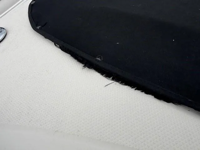 Slide: The Image of 2004 Sea Ray 240 Sundeck boat cover detail, showing black fabric and white textured surface. - 24