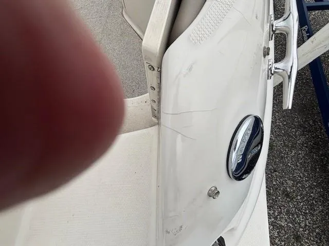 Slide: The Image of 2004 Sea Ray 240 Sundeck boat with visible scratches and a finger partially covering the lens. - 26