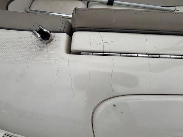 Slide: The Image of 2004 Sea Ray 240 Sundeck interior with visible wear and scratches on upholstery. - 28