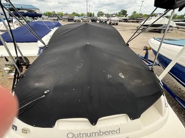 Slide: The Image of 2004 Sea Ray 240 Sundeck with black cover in a boatyard. - 36