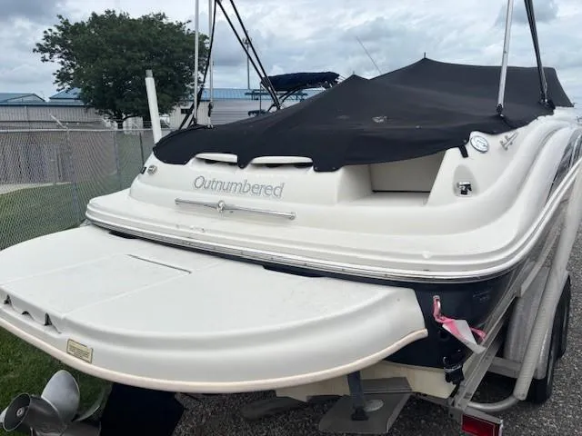 Slide: The Image of 2004 Sea Ray 240 Sundeck boat with black cover, parked on a trailer. - 38