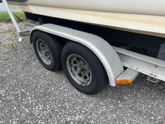 Slide: The Image of Trailer wheels of a 2004 Sea Ray 240 Sundeck boat on gravel. - 39