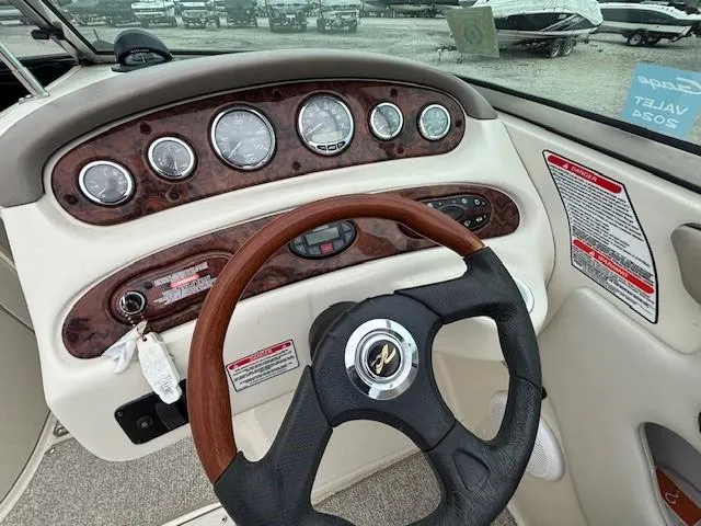 Slide: The Image of 2004 Sea Ray 240 Sundeck dashboard with gauges and steering wheel. - 4