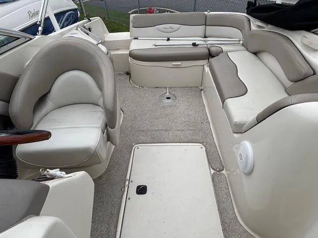 Slide: The Image of 2004 Sea Ray 240 Sundeck interior with beige seating and spacious layout. - 8