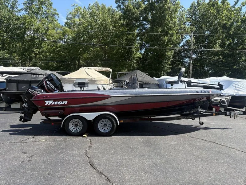 Slide: The Image of 2000 Triton TR205 DC Walleye boat on trailer, parked outdoors. - 0