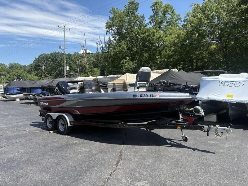 Slide: The Image of 2000 Triton TR205 DC Walleye boat on trailer, parked outdoors with trees in background. - 1