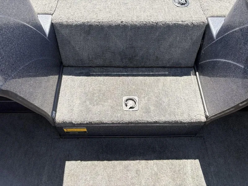 Slide: The Image of Interior of 2000 Triton TR205 DC Walleye boat, featuring carpeted steps and storage compartment. - 14