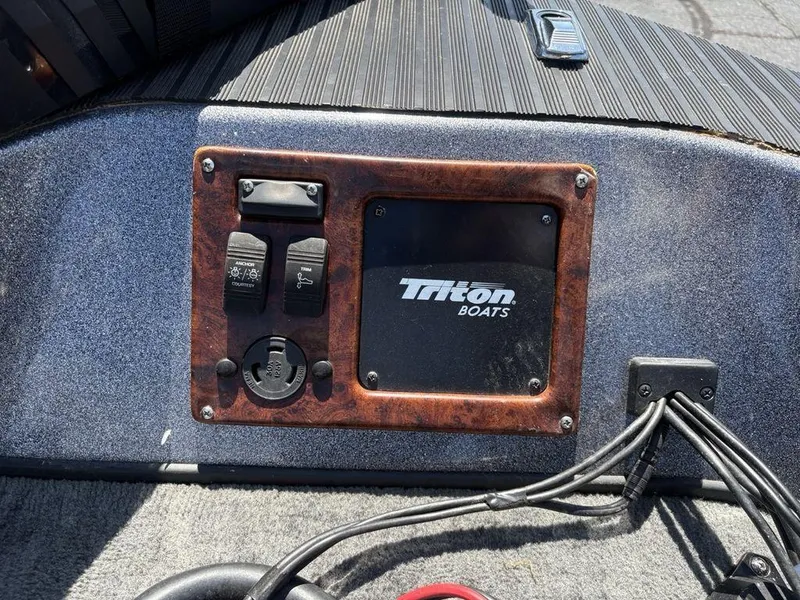 Slide: The Image of Control panel of a 2000 Triton TR205 DC Walleye boat with switches and logo. - 15