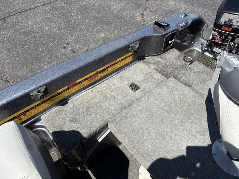 Slide: The Image of Interior of 2000 Triton TR205 DC Walleye boat with carpeted flooring and seating. - 16