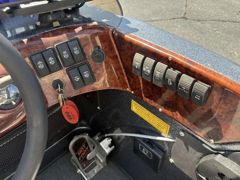 Slide: The Image of Dashboard of a 2000 Triton TR205 DC Walleye boat with control switches and key ignition. - 18