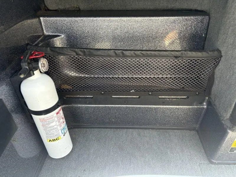 Slide: The Image of Fire extinguisher in 2000 Triton TR205 DC Walleye boat storage compartment. - 9