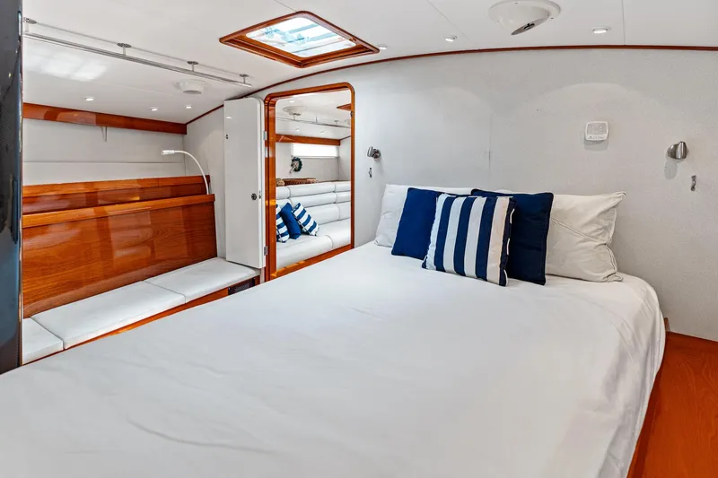Slide: The Image of Luxurious yacht bedroom with white bedding, blue pillows, and wooden accents, Custom Kelly Archer 1998. - 20