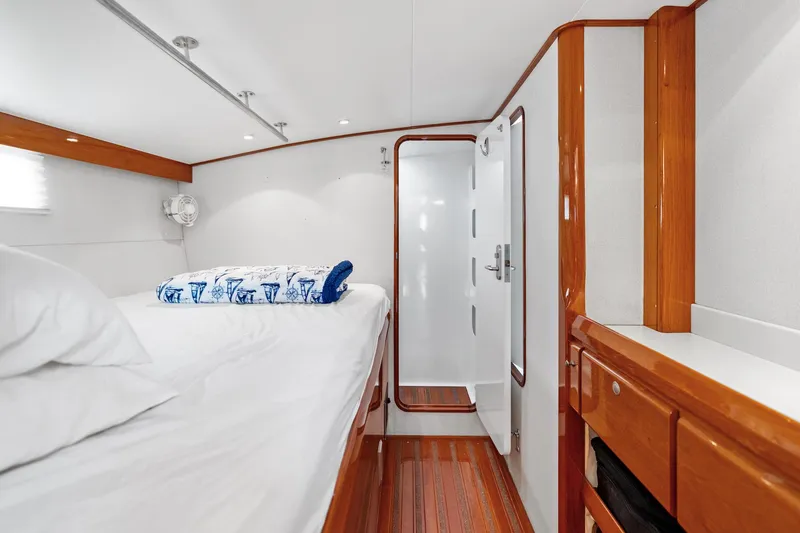 Slide: The Image of Luxurious yacht cabin with wooden accents, featuring a cozy bed and modern ensuite bathroom. - 25