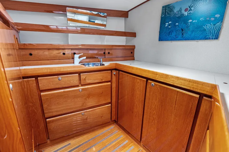 Slide: The Image of Luxurious wooden yacht interior with cabinets, sink, and ocean-themed artwork, Custom Kelly Archer 1998. - 29