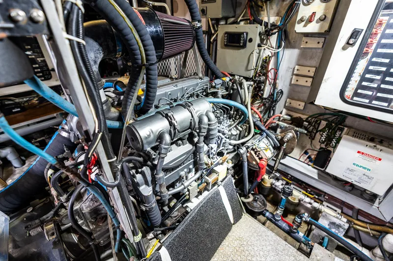 Slide: The Image of Engine room of a 1998 Custom Kelly Archer boat, showcasing complex machinery and wiring. - 36