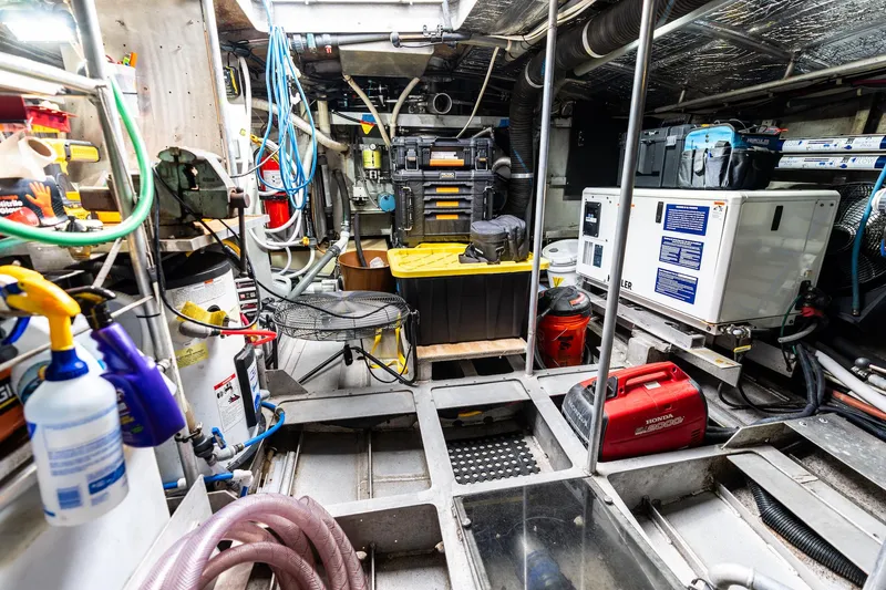 Slide: The Image of Engine room of a 1998 Custom Kelly Archer boat, featuring tools and equipment. - 43