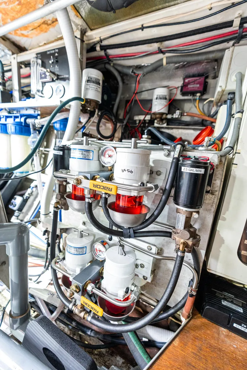 Slide: The Image of Engine room of a 1998 Custom Kelly Archer boat, showcasing complex piping and filtration systems. - 46