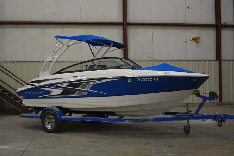 Slide: The Image of 2018 Monterey M-20 boat with blue accents on a trailer in a warehouse. - 0