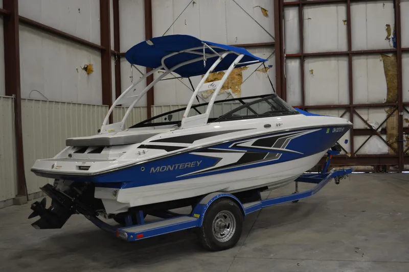 Slide: The Image of 2018 Monterey M-20 boat with blue and white design in a warehouse setting. - 1