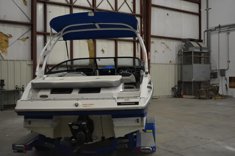 Slide: The Image of 2018 Monterey M-20 boat in warehouse, blue canopy, rear view. - 2