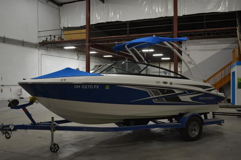 Slide: The Image of 2018 Monterey M-20 boat with blue accents on a trailer in a warehouse. - 4