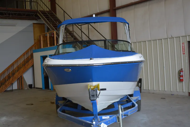 Slide: The Image of 2018 Monterey M-20 boat in blue and white, stored indoors on a trailer. - 5