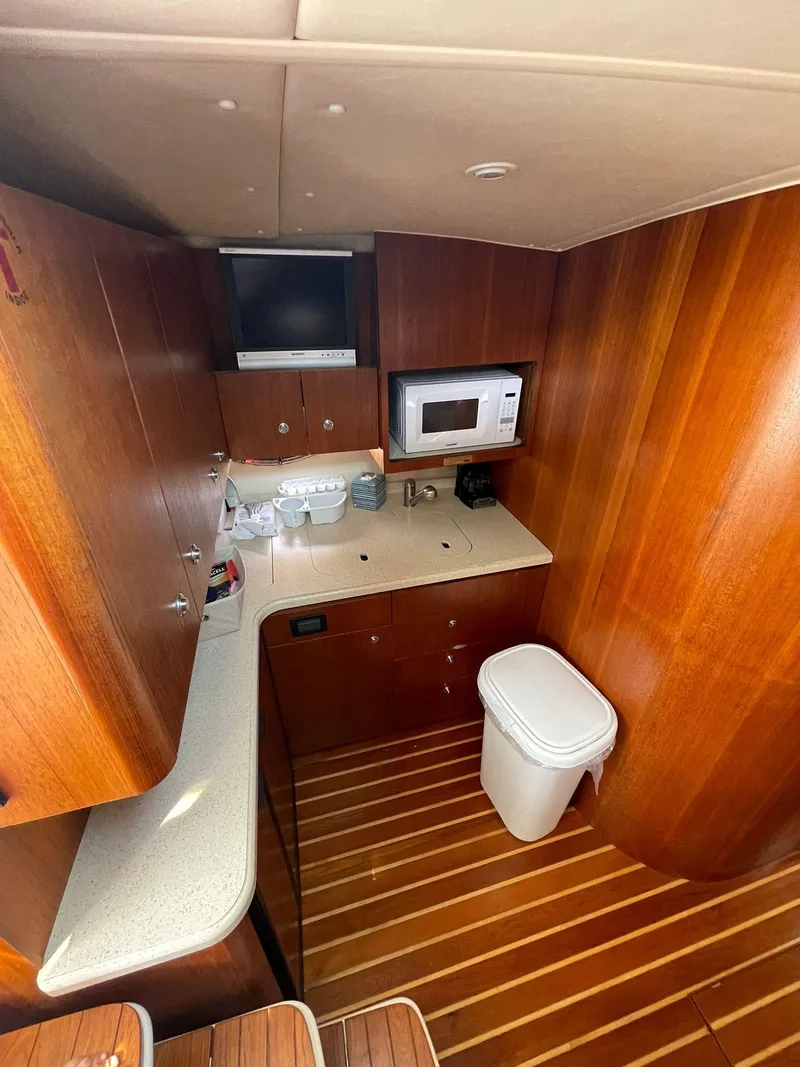 Slide: The Image of 2008 Tiara Yachts 3800 Open galley with wood cabinetry, microwave, and countertop. - 10