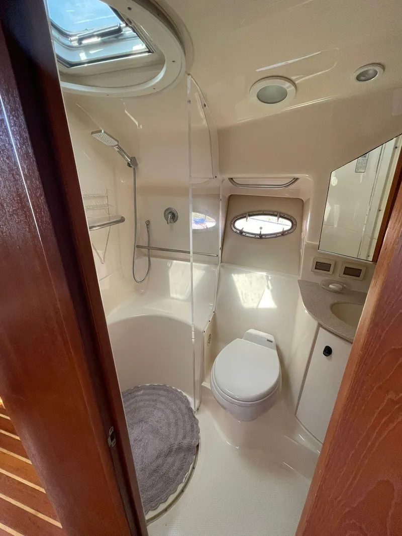 Slide: The Image of 2008 Tiara Yachts 3800 Open bathroom with shower, toilet, and porthole window. - 14