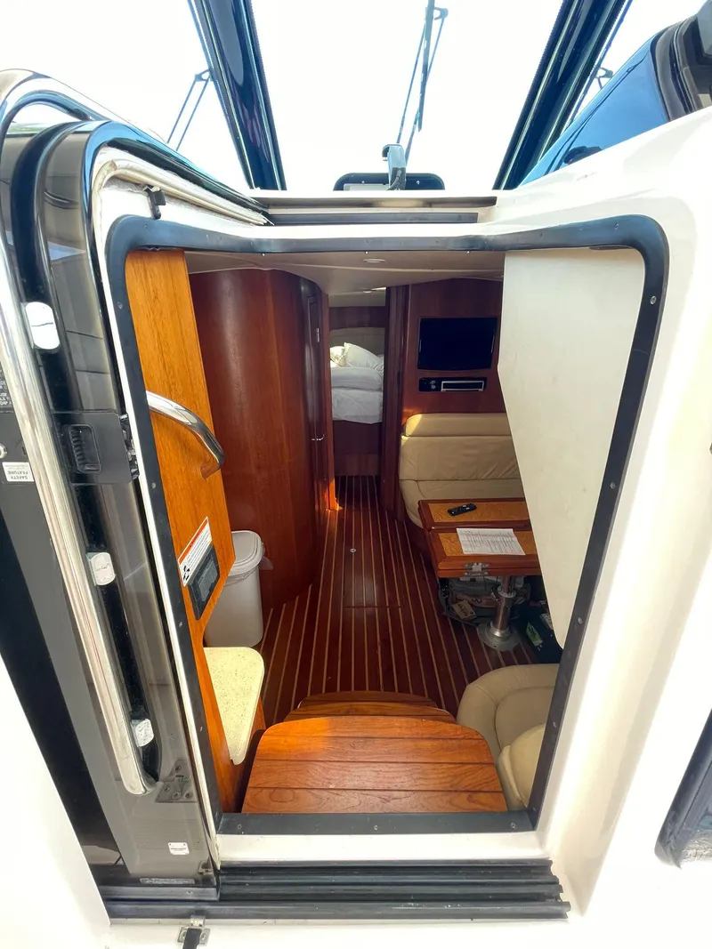 Slide: The Image of Interior view of 2008 Tiara Yachts 3800 Open, featuring wood finishes and cozy seating. - 5
