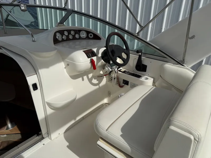 Slide: The Image of Interior of a 2001 Larson Cabrio 270 boat, helm and seating area. - 13
