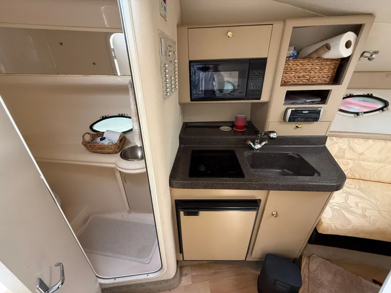 Slide: The Image of Interior of 2001 Larson Cabrio 270 yacht featuring kitchen and bathroom. - 22