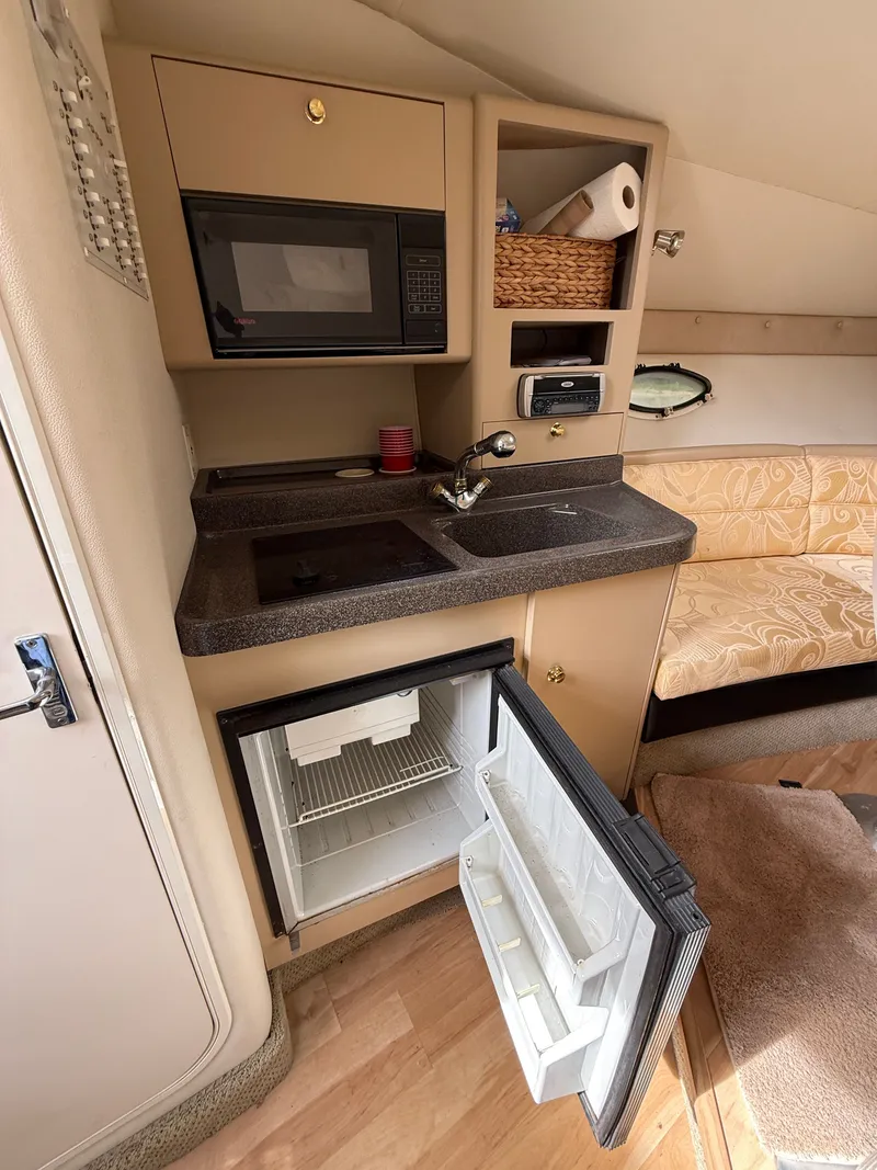 Slide: The Image of Interior of 2001 Larson Cabrio 270 with kitchenette and fridge. - 23