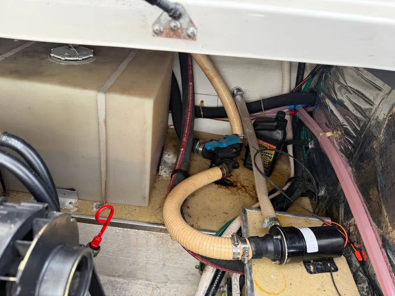 Slide: The Image of Engine compartment of a 2001 Larson Cabrio 270 boat with hoses and pump. - 29