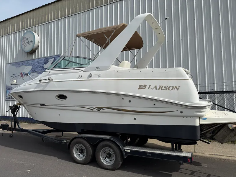 Slide: The Image of 2001 Larson Cabrio 270 boat on trailer in front of building. - 7