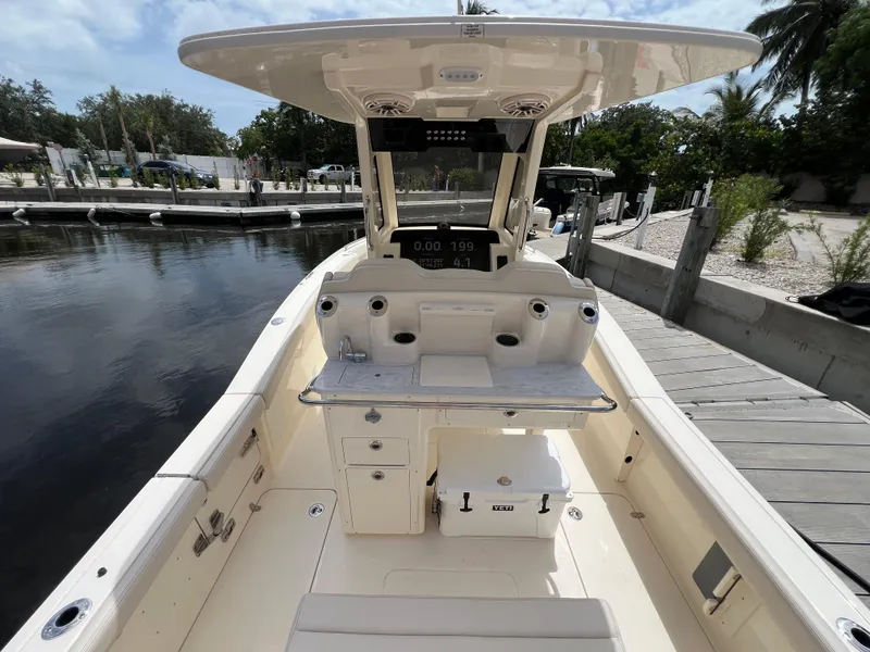 Slide: The Image of 2026 Scout 260 LXF boat interior at dock, featuring helm and seating area. - 10