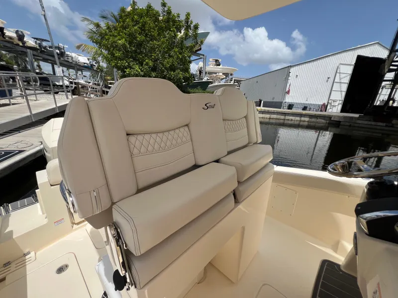 Slide: The Image of 2026 Scout 260 LXF boat interior with beige seating at a marina. - 20