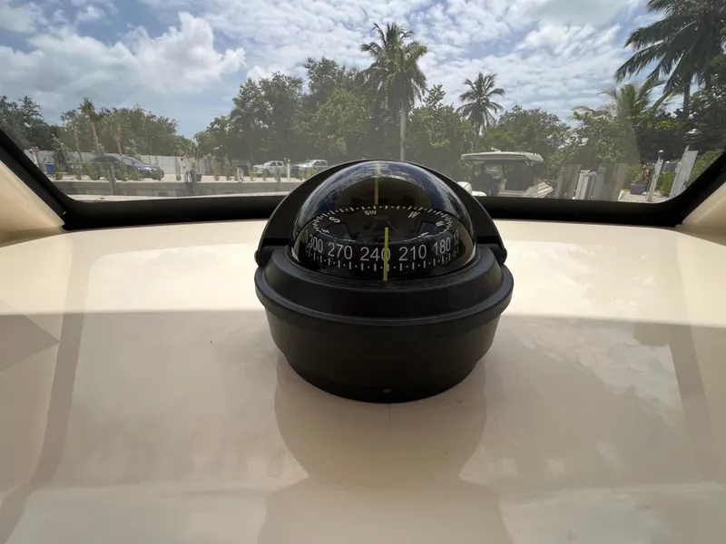 Slide: The Image of Compass on 2026 Scout 260 LXF boat, with tropical background and clear sky. - 25