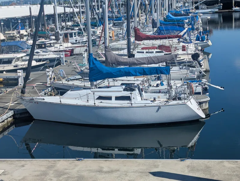 The Image of 1982 Goman Express 30 sailboat docked in a marina, surrounded by other boats. - 1