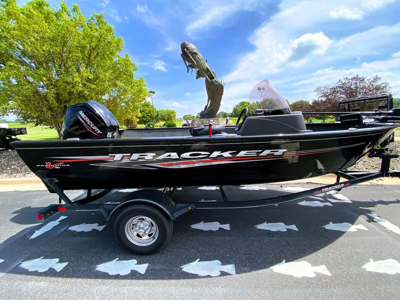 Slide: The Image of 2022 Tracker Pro Guide V-16 SC boat on trailer, parked outdoors under blue sky. - 2