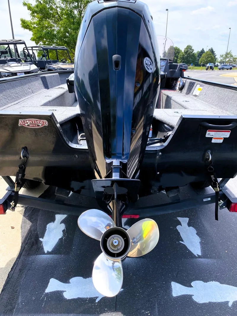 Slide: The Image of 2022 Tracker Pro Guide V-16 SC boat with outboard motor and propeller, parked outdoors. - 5