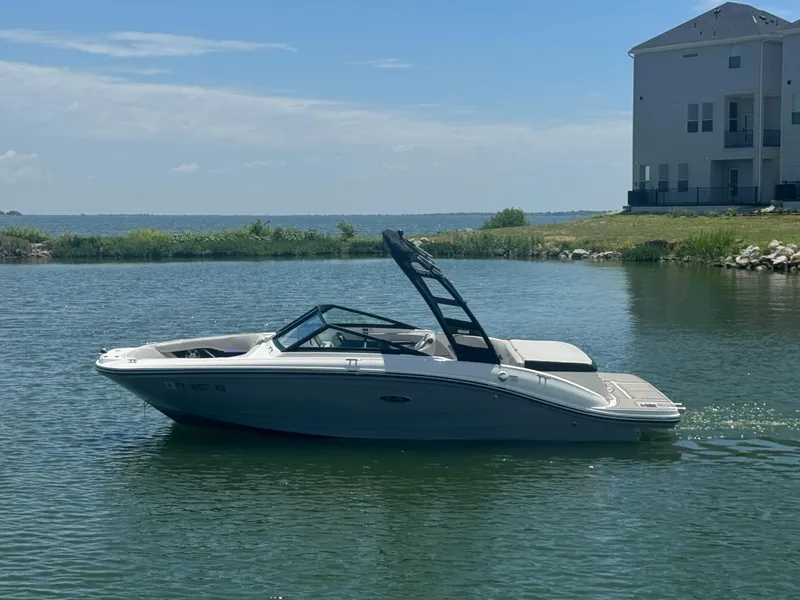 The Image of 2023 Sea Ray SPX 190 boat on a calm lake near a house. - 1